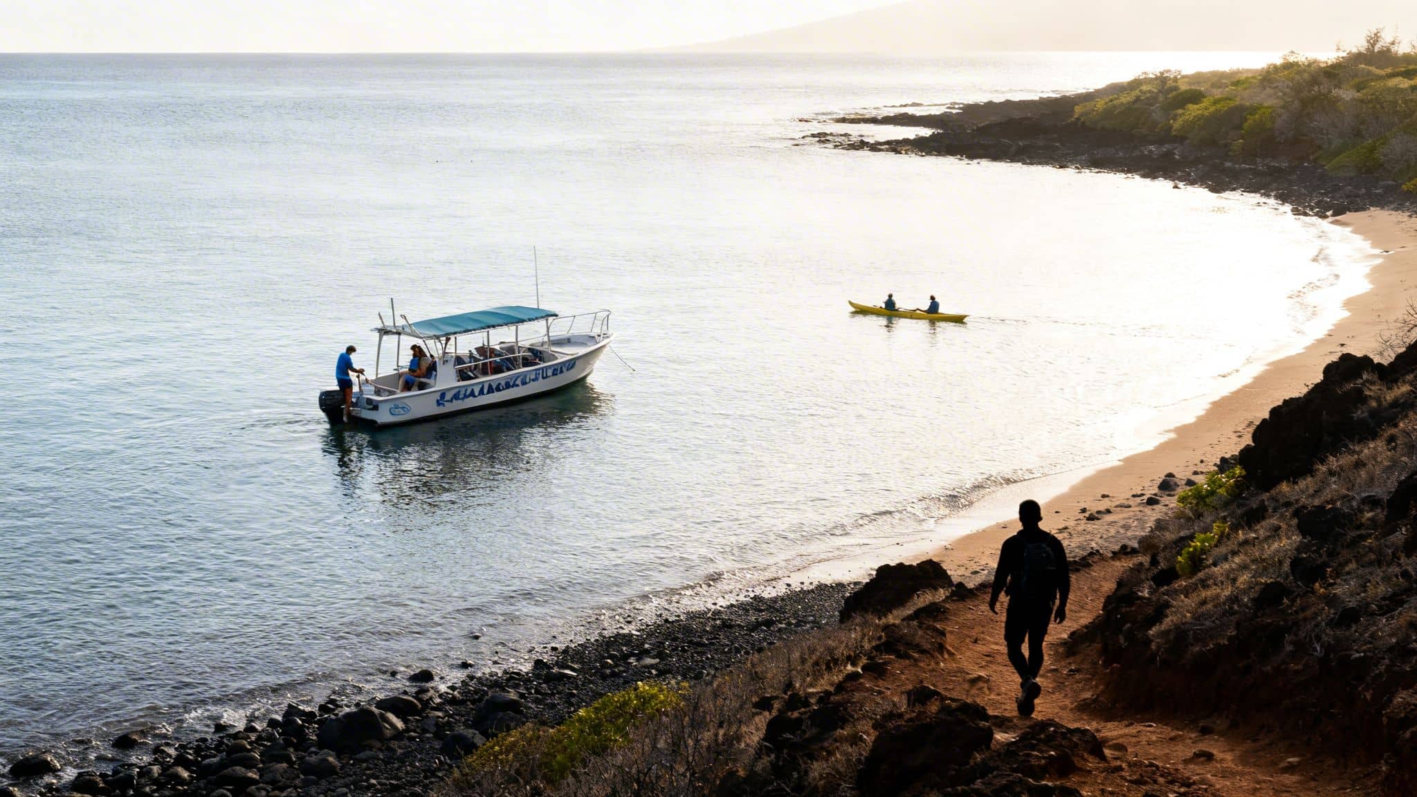 Coastal bay at sunset with a boat, two kayakers, and a person walking on a path.