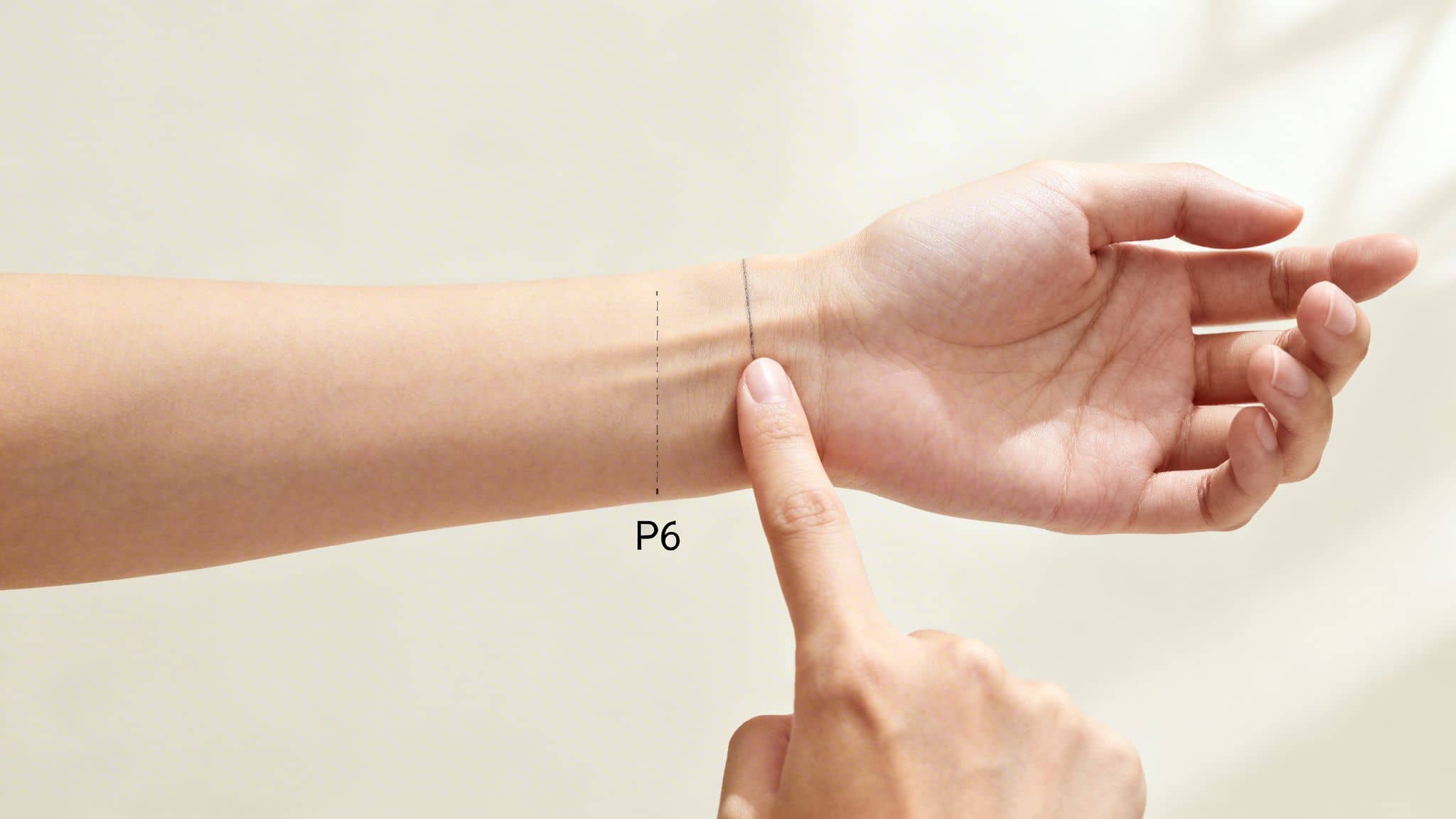 Close-up of a person's wrist with lines and 'P6' indicating the pericardium 6 acupressure point.