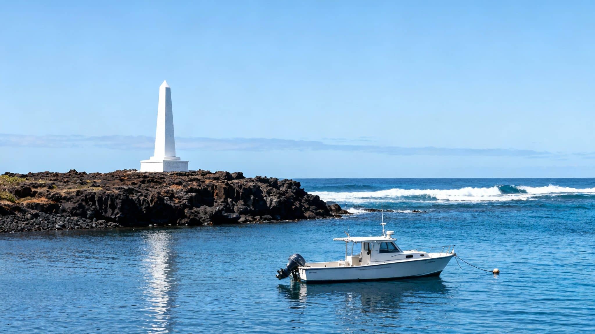 A white obelisk monument stands on a volcanic rock coastline with a white boat in clear blue water.